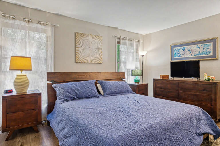 Sink into the plush linens of your private retreat, where warm wood tones and soft natural light create a calming ambiance. Your mornings begin peacefully here, surrounded by thoughtful details and modern comforts designed for total relaxation.