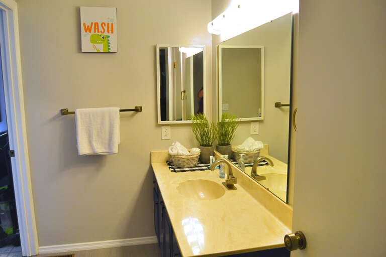 Step into your freshly updated bathroom with soft lighting, a spacious vanity, and thoughtful touches like fluffy towels and greenery to make you feel right at home.