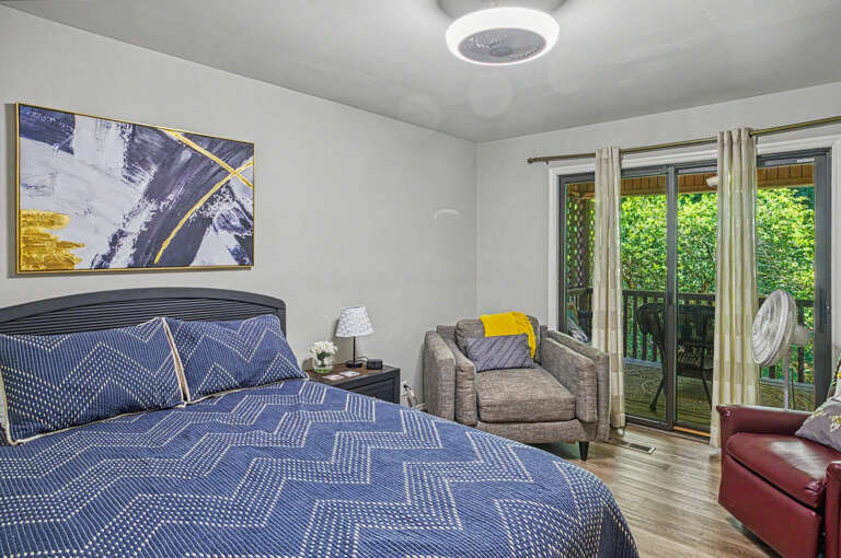 Step into your serene bedroom where plush bedding invites restful sleep and a private balcony opens to lush greenery, creating your peaceful retreat.