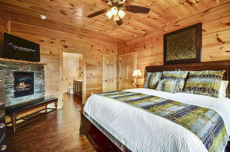 Fireplace and TV by a large bed.