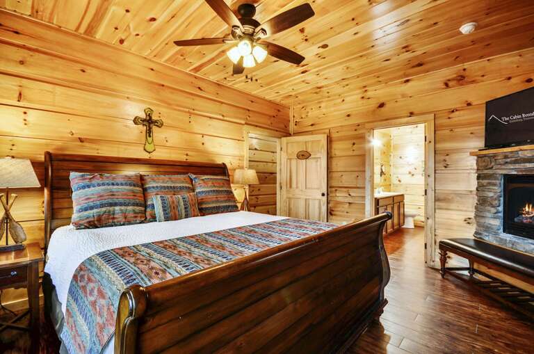 Wall-mounted TV above a fireplace in a bedroom.