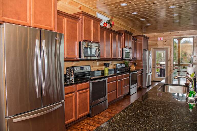 Kitchen with Two Refrigerators, Two Microwaves, and Two Stoves.