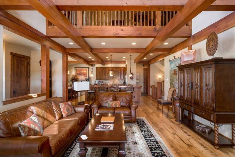 Spacious Living Space With Leather Sofas, Wood Ceilings, And Detailed Cabinetry