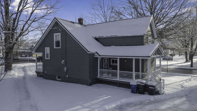Snow-covered House With Front Porch In Winter Snow-covered House With Front Porch In Winter