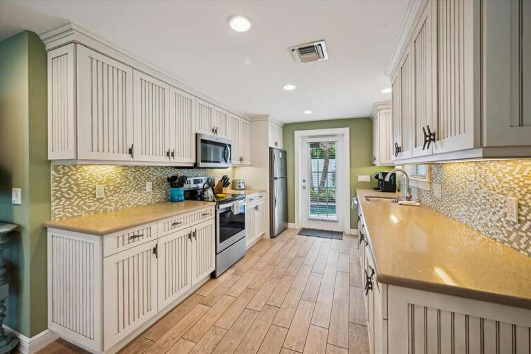 Bright, Beige Kitchen With Breakfast Bar In Vacation Rental