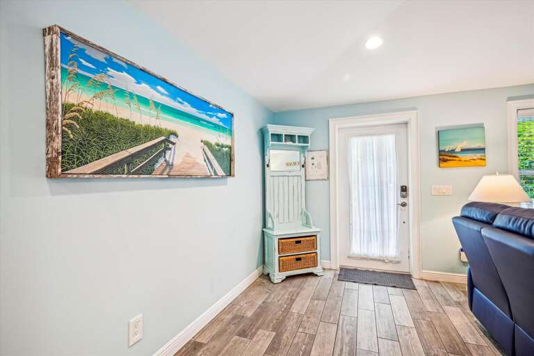 Bright Beach-themed Room With Seaside Paintings And Light Wooden Floors
