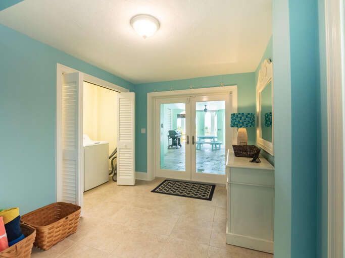 Blue Breezeway Leading Into Tiled Living Area With Visible Seating