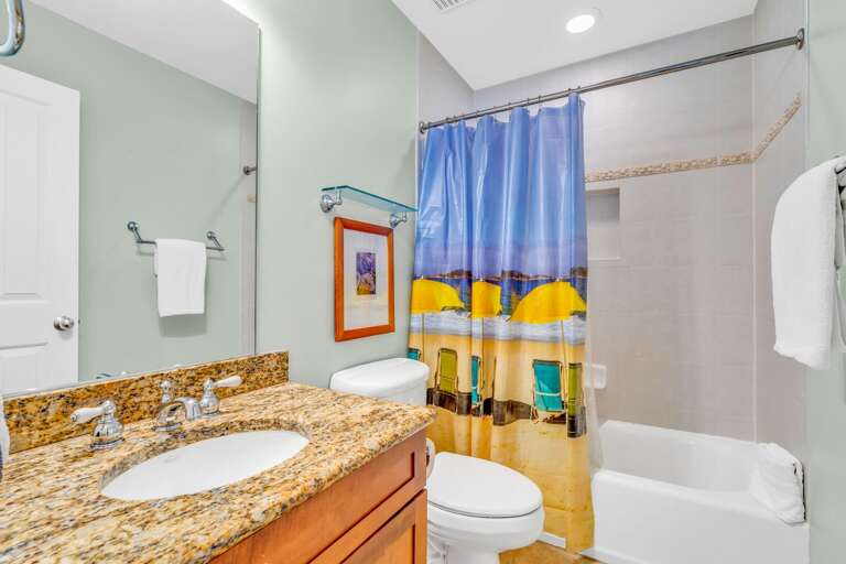Bright shared bathroom in a Marathon FL canal-front vacation home offering a convenient shower/tub combo and modern coastal finishes.