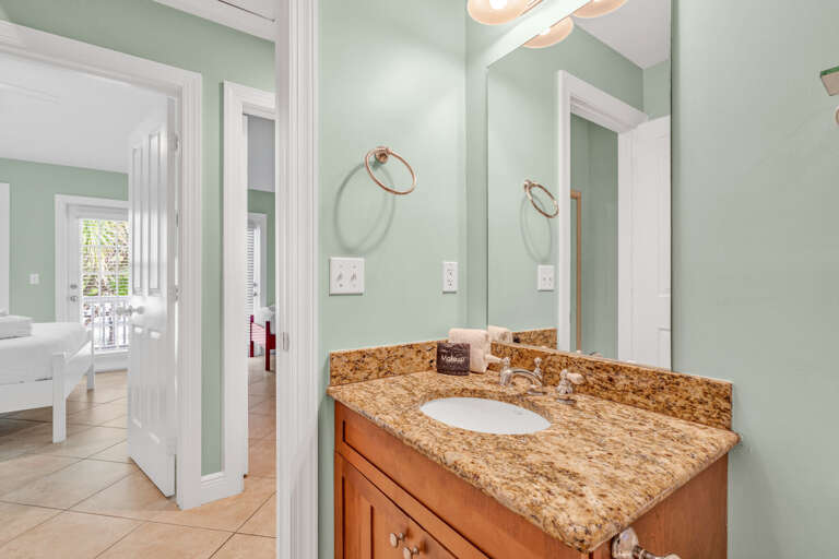 Clean and spacious shared bathroom in a luxury Marathon Florida Keys waterfront vacation rental featuring a shower and tub combo — perfect for families and group stays.