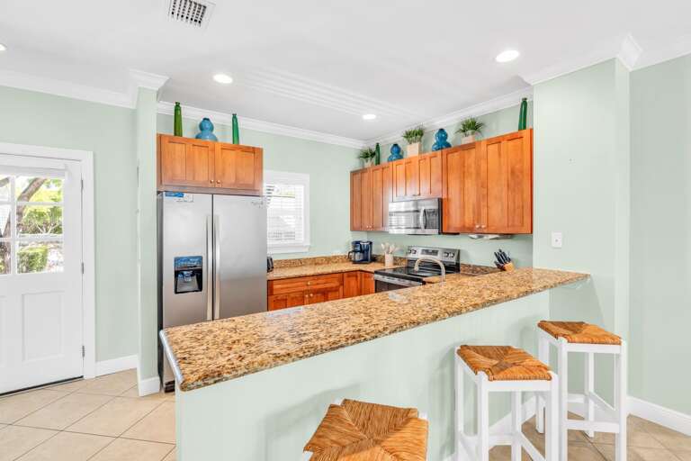 Spacious gourmet kitchen in a luxury Marathon Florida Keys waterfront vacation home featuring modern appliances, canal views, and community pool access — perfect for family stays and group getaways.