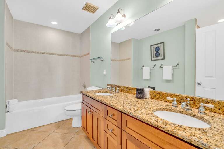 Upscale en-suite bathroom in a luxury Marathon Florida Keys vacation home with sleek finishes and dual vanity sinks.