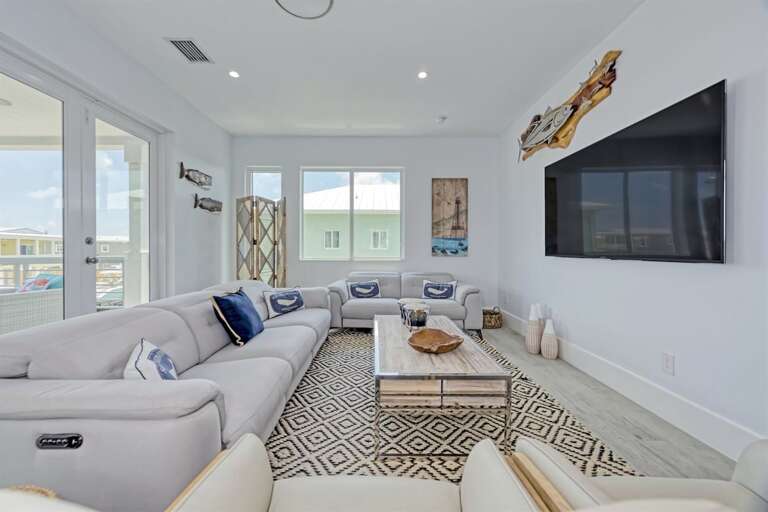 Main living area hosts reclining sofas and 75 smart TV.