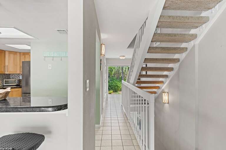 Stairs/hallway to den with a beautiful solar-tinted window to let in natural light without the heat.