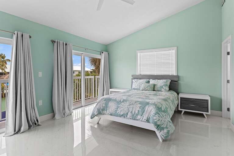 Bedroom 4 on the second level featuring a queen bed and en-suite full bathroom.