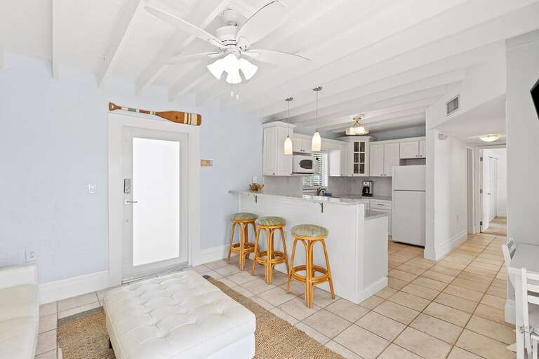 Full kitchen with bar stools, TV, and cozy nooka perfect space for cooking and casual dining.