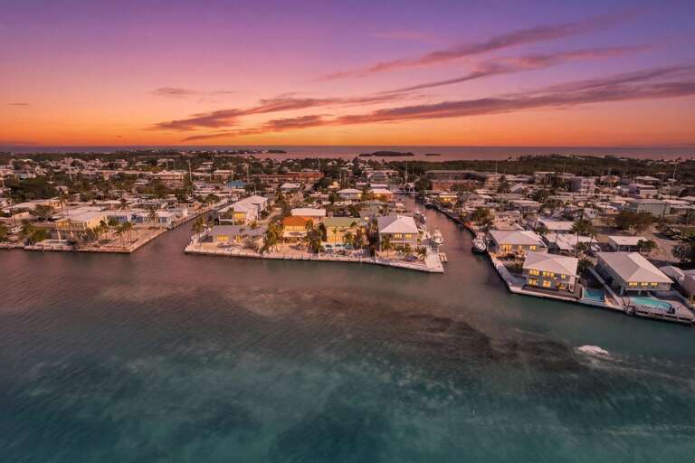 Luxury oceanfront home with tiki hut, private pool, and expansive outdoor living space overlooking the water in Marathon, FL.