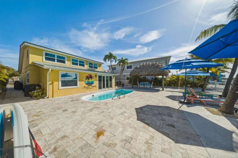 Oceanfront backyard with pool, fire pit, and multiple outdoor living spaces for entertaining.