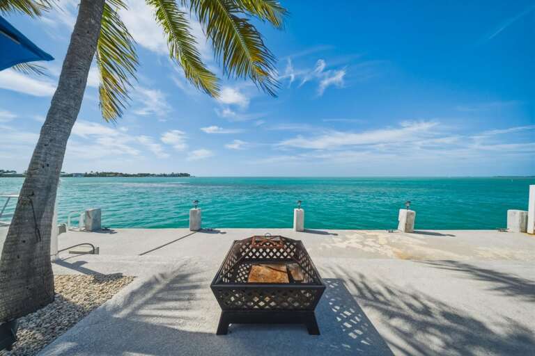Oceanfront fire pit area with stunning sunset views, creating the perfect setting for relaxing evenings by the water.