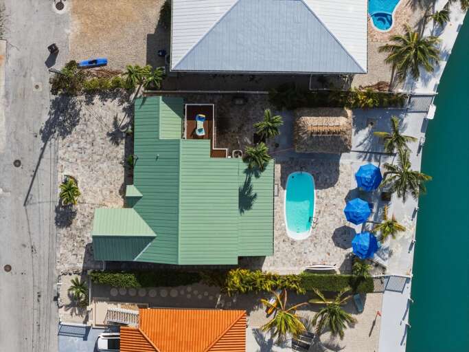 Outdoor dining and tiki hut seating area beside the oceanfront pool at this luxury Marathon vacation home.