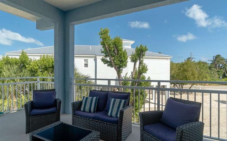 Spacious balcony overlooking the pool with plenty of seating for relaxing or outdoor dining.