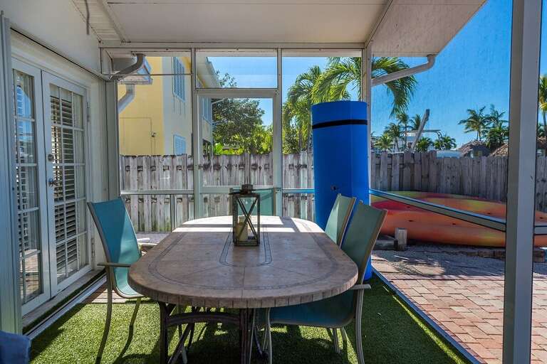 Screened-in porch with plenty of seating and TV