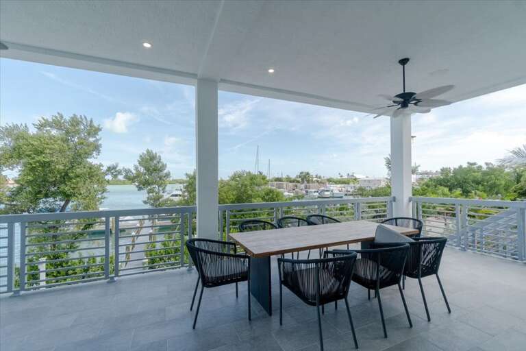 Outdoor dining balcony overlooking the pool and open waters.