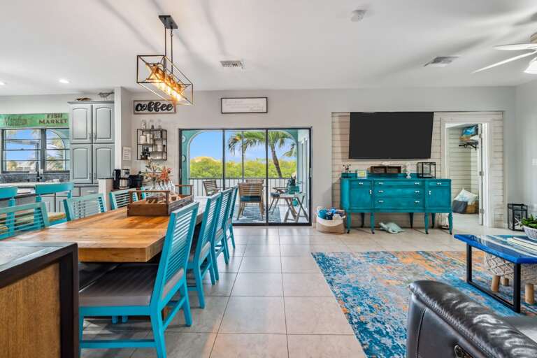 Open-concept living room with coastal decor and flat-screen TV in Marathon FL rental.