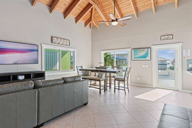Airy elegance: Open-concept living, kitchen, and dining area beneath soaring ceilings. Airy elegance: Open-concept living, kitchen, and dining area beneath soaring ceilings.