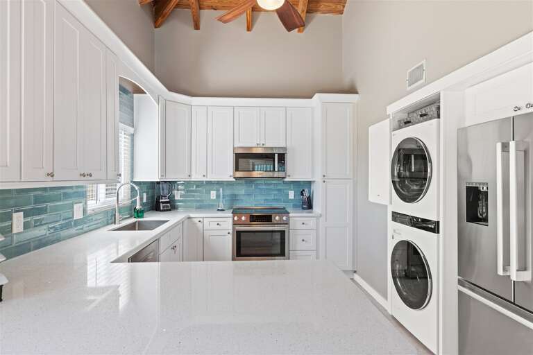 Modern kitchen equipped with washer and dryer for added convenience. Modern kitchen equipped with washer and dryer for added convenience.
