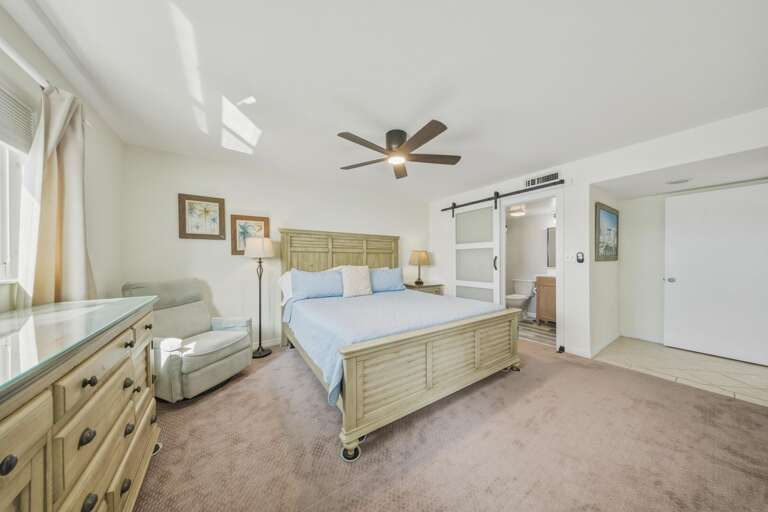 A king-size bed, comfortable seating area, and soothing shades of blue create a spacious bedroom designed for comfort.