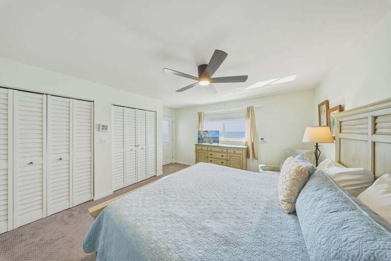 Soft neutral tones, light wood furnishings, and ample storage create a comfortable bedroom with a bright, airy feel.