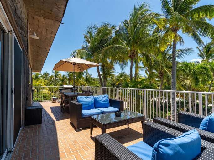 Balcony off of the living room with seating, outdoor dining, and propane grill