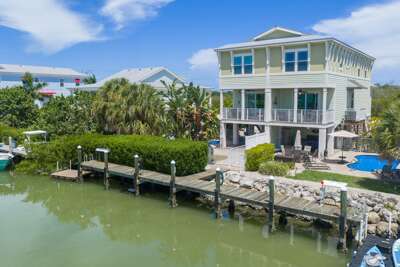 Discover a spacious waterfront vacation home on Sombrero Beach Road in Marathon, Florida, featuring a private pool, canal access, dock, and tropical outdoor spaces in the heart of the Florida Keys.