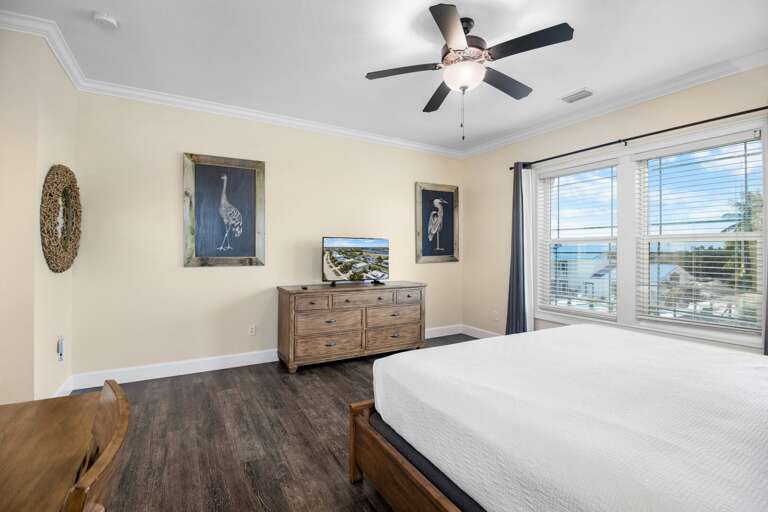Multiple windows fill this roomy Marathon bedroom with natural light while coastal decor creates a peaceful atmosphere.