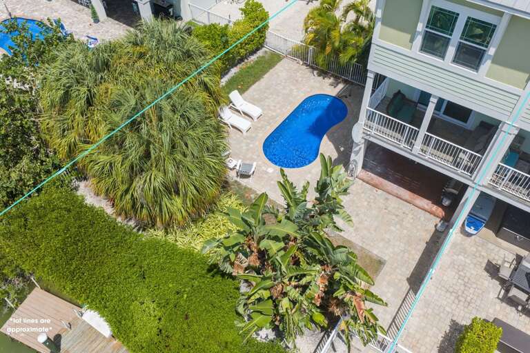 This overhead view captures the private pool, tropical backyard, elevated home, and waterfront setting near Sombrero Beach.