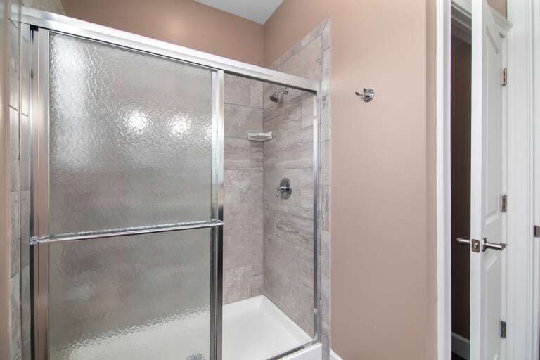 Refresh after a beach or boating adventure in a glass-enclosed shower with attractive tile and modern fixtures.