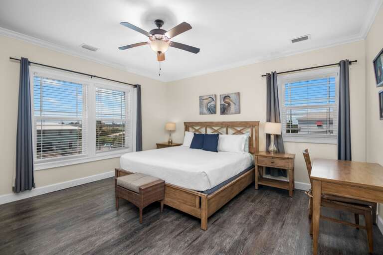 Relax in a spacious bedroom with a comfortable bed, writing desk, ceiling fan, and abundant Florida sunshine.