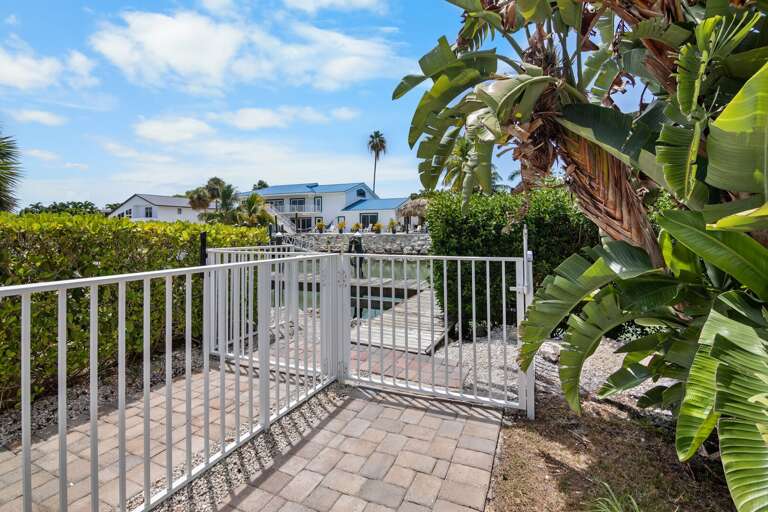 A secure gated entrance leads to the private pool and tropical outdoor living area at this Marathon, Florida, vacation home.
