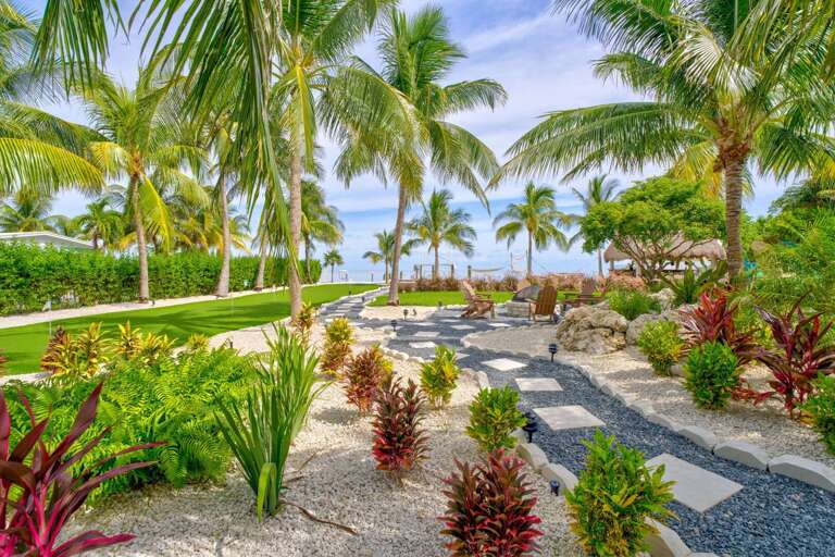 A beautifully maintained private yard with lush tropical foliage, perfect for families seeking space to relax and play during their Florida Keys vacation.