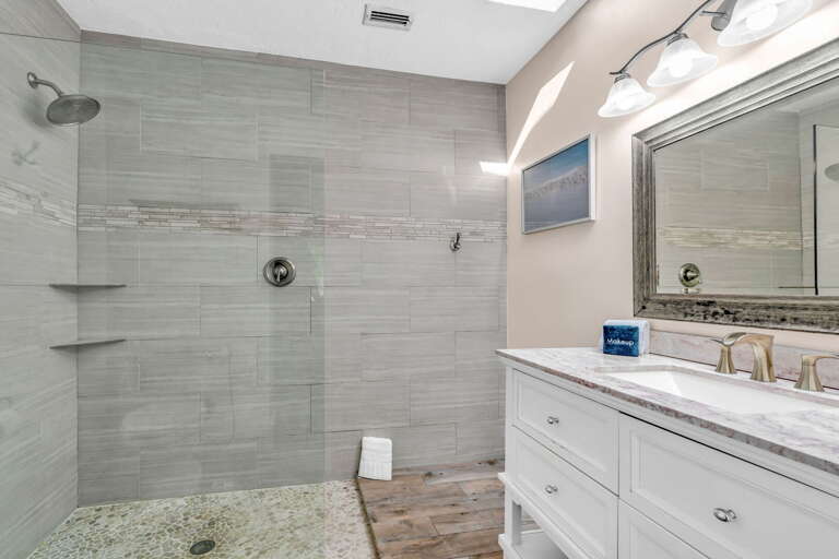 Bright and airy, this master bathroom features a skylight that floods the space with natural light, enhancing the luxurious atmosphere of this Florida Keys vacation rental.