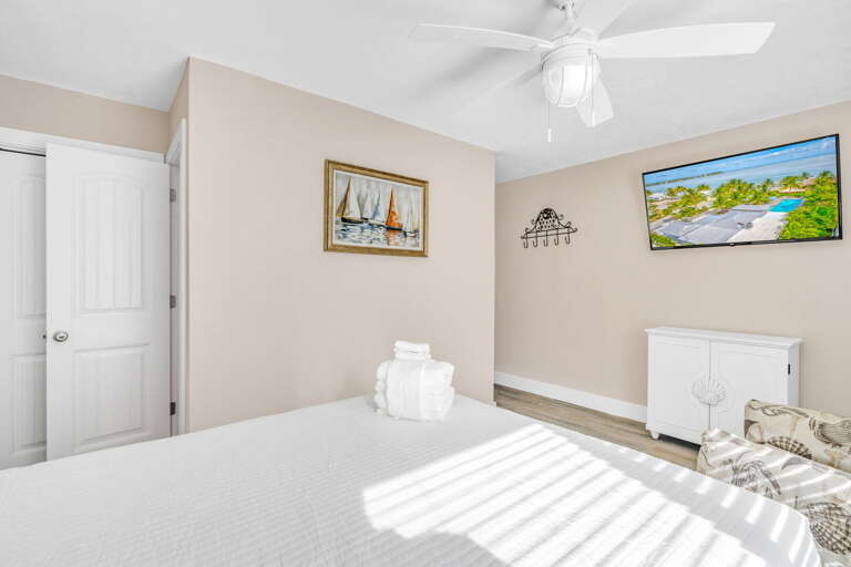 This bright and inviting Bedroom 2 includes a queen bed, smart TV, and private ensuite bathroom, providing comfort and privacy for guests at this luxury Marathon rental.