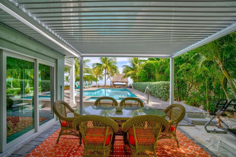 Enjoy meals al fresco in this oceanfront outdoor dining area, featuring comfortable seating and stunning water views, perfect for gatherings, sunsets, and tropical evenings in the Florida Keys.