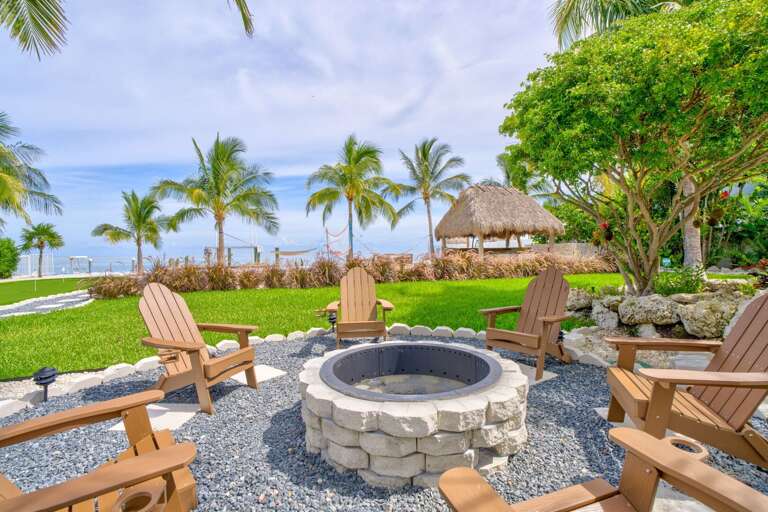 This luxury fire pit area offers a cozy and inviting space for guests to unwind, featuring comfortable seating and stunning ocean views.