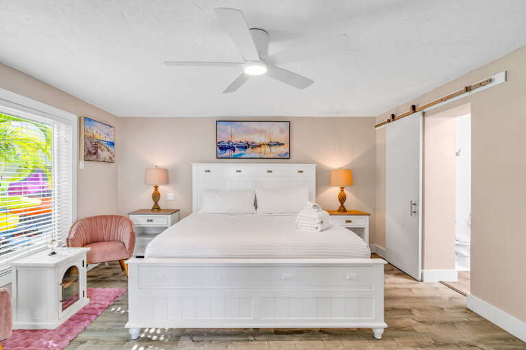 Relax in the spacious master bedroom featuring stunning ocean views and a private ensuite bathroom, designed for comfort and tranquility in this luxury Florida Keys vacation home.
