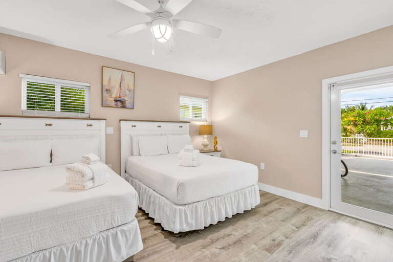 This spacious Bedroom 3 offers two full beds, a smart TV, and a private ensuite bathroom, perfect for guests seeking comfort and privacy in Marathon, Florida Keys.