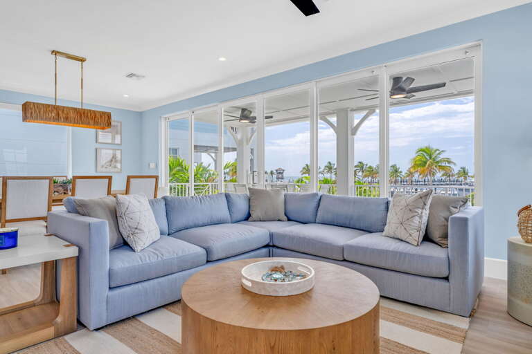 The open layout seamlessly connects the kitchen, dining, and living areas, all overlooking the Gulf of Mexico, making this rental ideal for families and large groups.