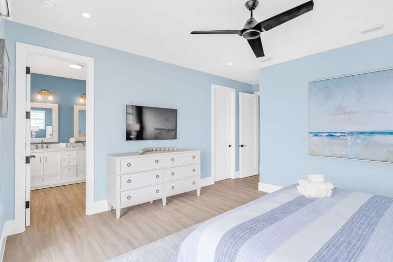 This spacious master bedroom offers direct water views, modern coastal décor, and a private balcony, perfect for relaxing mornings in your luxury Florida Keys rental.