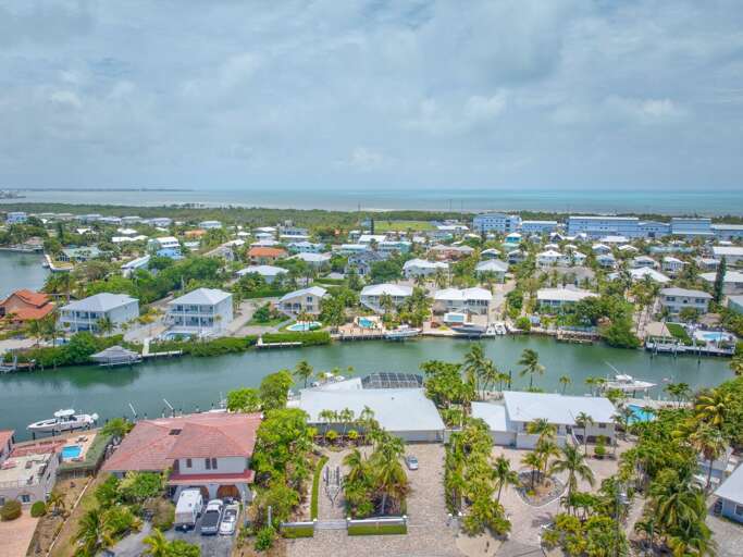 Aerial photo highlighting tropical landscaping, screened outdoor kitchen, and large dock for Florida Keys vacations. Aerial photo highlighting tropical landscaping, screened outdoor kitchen, and large dock for Florida Keys vacations.