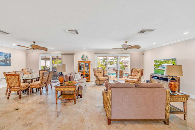 Florida Keys vacation rental living room in Marathon featuring ample seating, a large flat-screen TV, and views of the pool and waterfront. Florida Keys vacation rental living room in Marathon featuring ample seating, a large flat-screen TV, and views of the pool and waterfront.