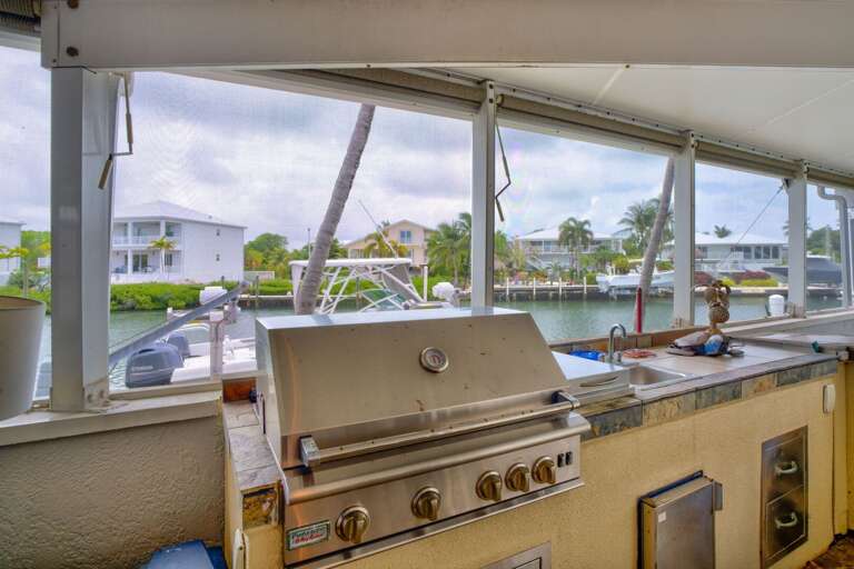 Fully equipped outdoor kitchen with grill, sink, mini fridge, burner, and ice maker at a luxury Florida Keys vacation rental. Fully equipped outdoor kitchen with grill, sink, mini fridge, burner, and ice maker at a luxury Florida Keys vacation rental.